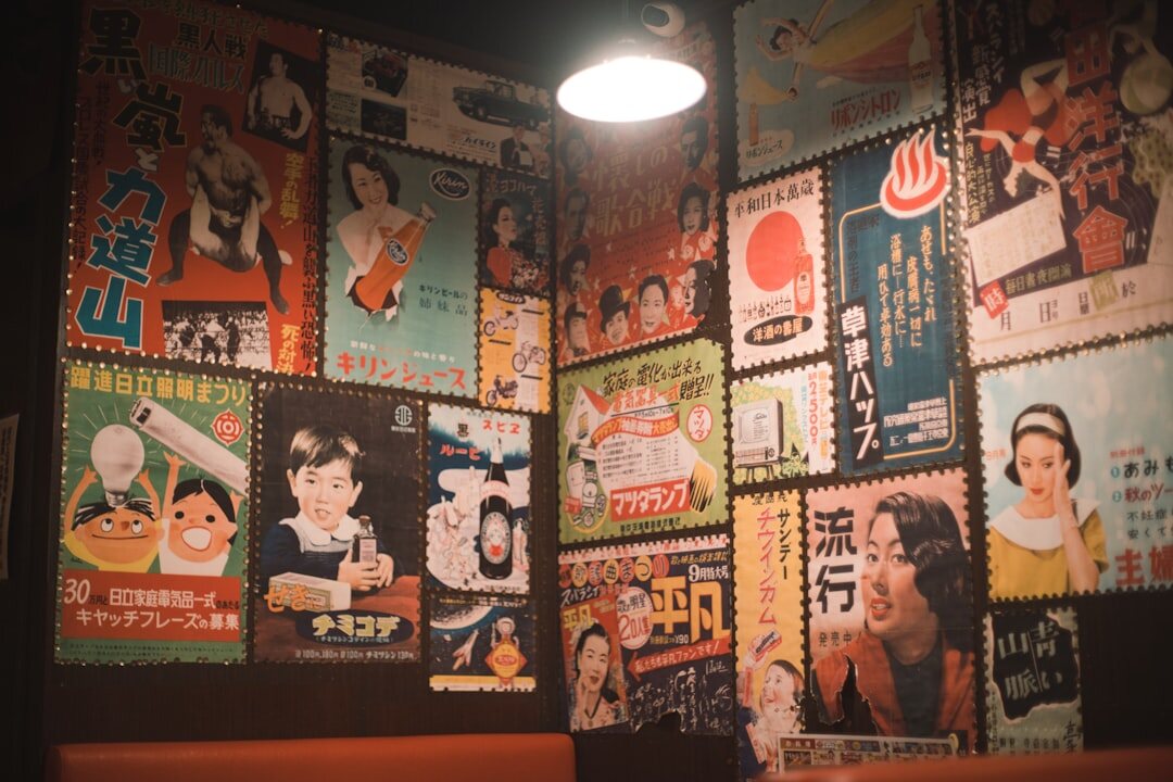 Wall covered with layered vintage advertising posters from the 1980s and 1990s